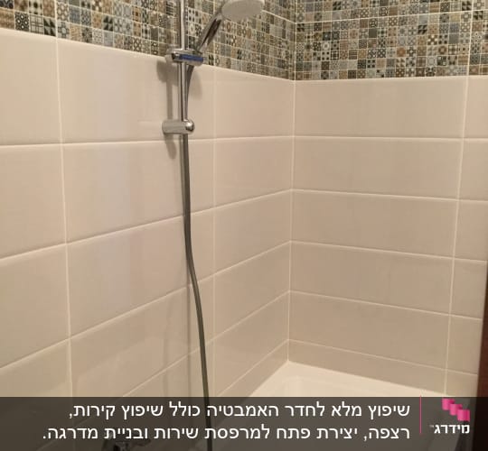 אמבטיה עם אריחים חדשים וברז מקלחת מותקן